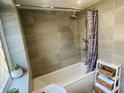 een badkamer met een bad, een toilet en een douche bij Tranquil Bridge Escape in Canterbury