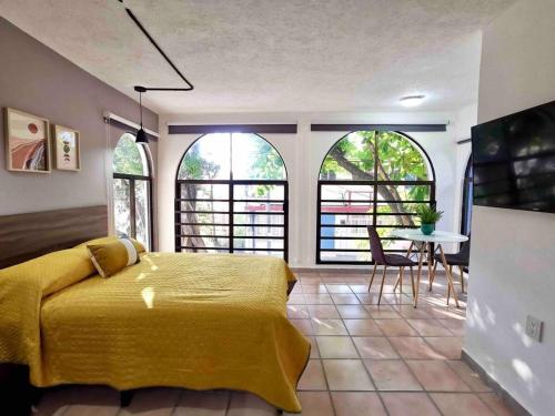 a bedroom with a yellow bed and a table with chairs at Estudio 2 personas en el Centro/agencias aduanales in Veracruz