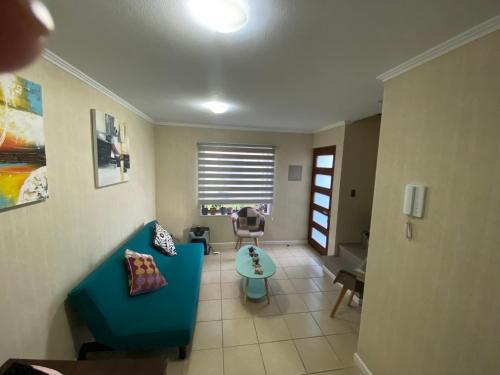 a living room with a blue couch and a table at Casa condominio para 3 personas in Angol