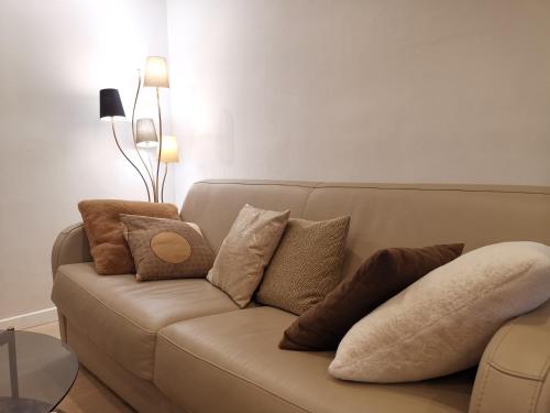 un canapé avec des coussins dessus dans un salon dans l'établissement LE CHESTER - Appartement 3 pièces - Cannes proche Croisette bord de mer, à Cannes