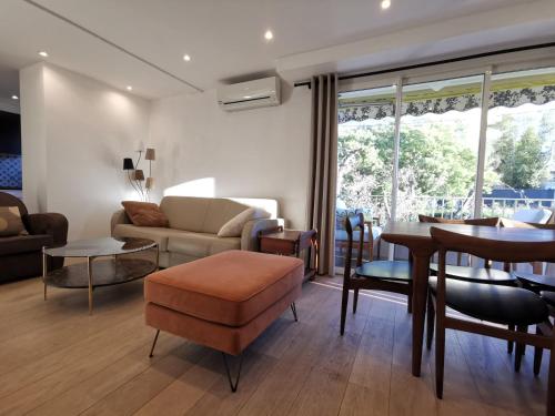 a living room with a couch and a table at LE CHESTER Appartement 3 pièces Cannes proche Croisette bord de mer in Cannes