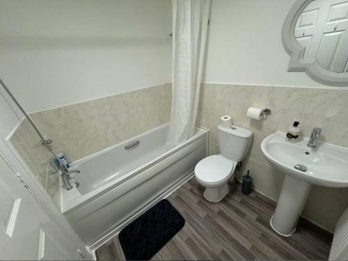 biała łazienka z toaletą i umywalką w obiekcie Modern TownHouse - 3 bed 2.5 bath 2 Private Gated Parking w mieście Wellingborough