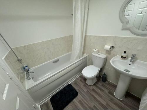 a white bathroom with a toilet and a sink at Modern TownHouse - 3 bed 2.5 bath 2 Private Gated Parking in Wellingborough