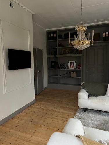 uma sala de estar com mobiliário branco e um lustre em Pastors Prästgården em Norberg