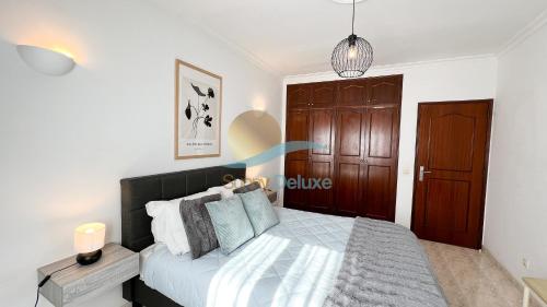 a bedroom with a large bed with a wooden door at Villa Bea by Sunny Deluxe in Albufeira