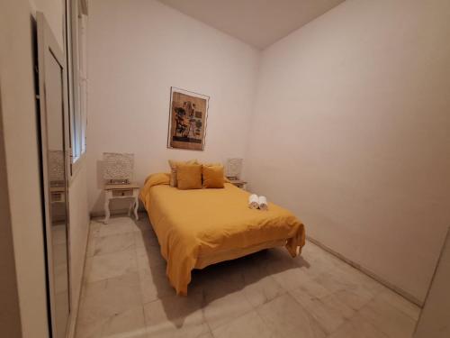 a bedroom with a bed with a yellow blanket at Budget & Lovely Rooms Las Setas in Seville