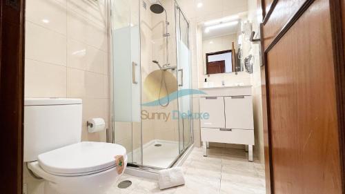 a bathroom with a toilet and a glass shower at Villa Bea by Sunny Deluxe in Albufeira