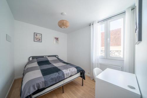 ein weißes Schlafzimmer mit einem Bett und einem Fenster in der Unterkunft Maison rénové proche Paris 15. in Malakoff
