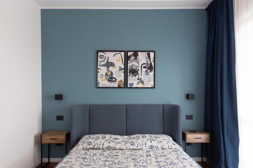 a bedroom with a bed with three pictures on the wall at Exclusive Guest House - Fiera Milano Rho in Rho