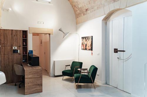 a living room with green chairs and a table at Le Vie Del Centro Luxury Room in Matera