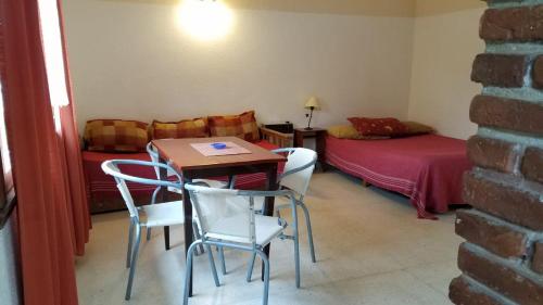 een kamer met een tafel en stoelen en een bed bij La caracola in Villa Gesell