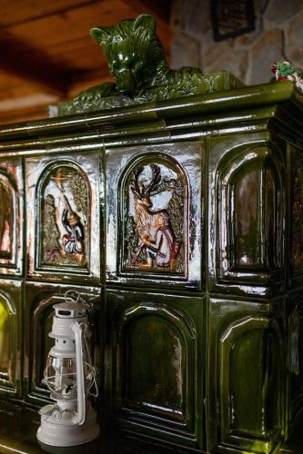 a green cabinet with paintings on it with a camera at Mała Bawaria in Zakopane