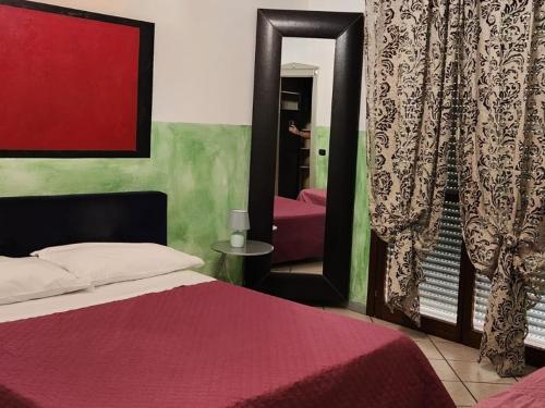 a bedroom with a bed and a mirror and a pink couch at Apartment Airport in Bergamo