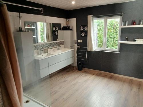 een badkamer met 2 wastafels en een glazen douche bij l'arche de noé 