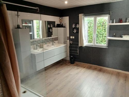 a bathroom with two sinks and a glass shower at l'arche de noé in Tournay-sur-Odon