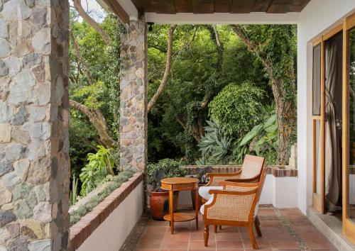 a patio with two chairs and a table at Hotel Casa Palopo in Santa Catarina Palopó