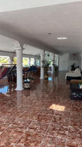 a large room with columns and a room with a bed at Casa Gajah Hotel Cuyo in El Cuyo