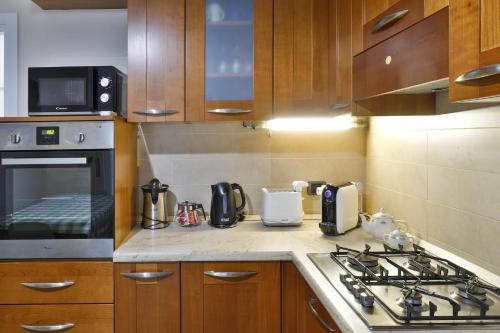 a kitchen with wooden cabinets and a stove top oven at DANTE SUITE in Como