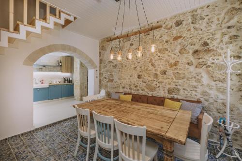 a kitchen and dining room with a wooden table and chairs at Minoos Residence with roof pool in Rethymno