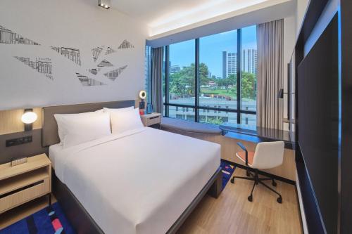 a bedroom with a bed and a desk and a window at Aloft Singapore Novena in Singapore