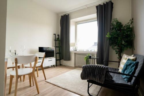 een woonkamer met een tafel en een eetkamer bij Chic Urban Oasis at Helsinki Activity Center in Helsinki