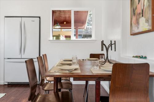 a kitchen with a wooden table with chairs and a refrigerator at Bodega Breeze in Bodega Bay