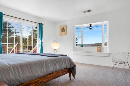a bedroom with a bed and two windows at Bodega Breeze in Bodega Bay