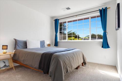 a bedroom with a bed and a window with blue curtains at Bodega Breeze in Bodega Bay
