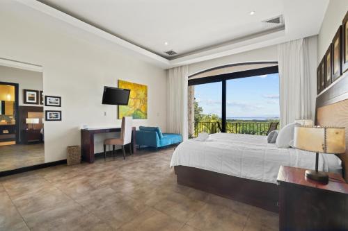 a bedroom with a bed and a desk and a window at Villa Buena Onda All Inclusive in Coco