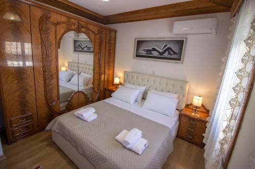 a bedroom with a bed with two towels on it at Emblematic House 3 in Gjirokastër