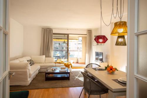 a living room with a white couch and a table at SingularStays Palacio de Congresos in Valencia