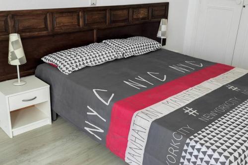 1 dormitorio con 1 cama con edredón blanco y negro en Tenerife Sur, en Arona