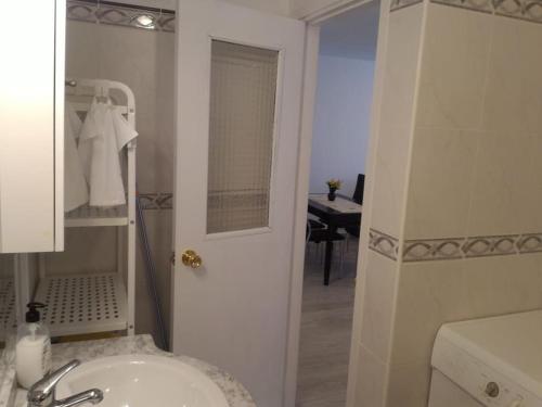 Baño blanco con lavabo y espejo en Tenerife Sur, en Arona