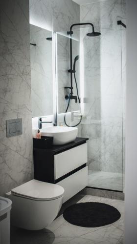 a bathroom with a toilet and a sink and a shower at MA Housing West Tower - 14th, 13th, 12th, 9th floor in Cluj-Napoca