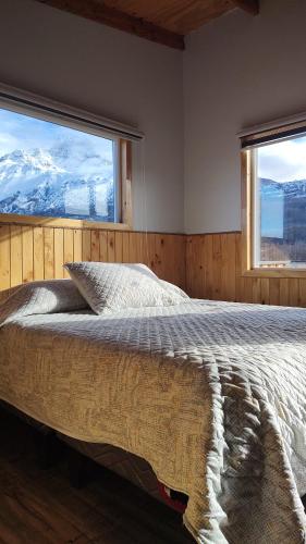 1 dormitorio con 1 cama y vistas a las montañas en Cabañas y Restaurante Ruta 7 sur, en Villa Cerro Castillo