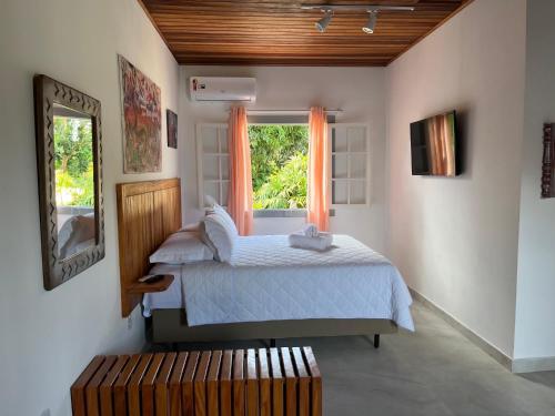 um quarto com uma cama e uma janela em Casa Arte Cabore em Paraty