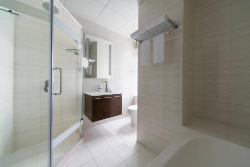 a bathroom with a shower and a toilet and a sink at Marriott Executive Apartments City Center Doha in Doha
