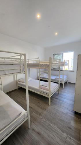 a room with three bunk beds in it at Blife Faro Beach Hostel & Rooms in Faro