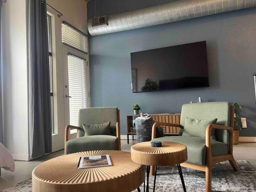 a living room with two chairs and a tv on the wall at San Diego Gaslamp Loft Getaway in San Diego