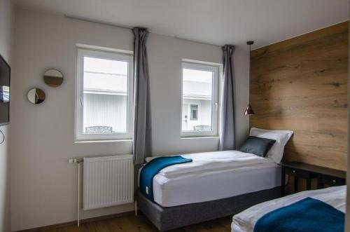 um quarto com 2 camas e 2 janelas em Stracta Apartments em Kirkjubæjarklaustur