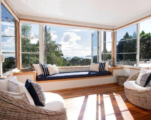 a living room with two chairs and a large window at Private Luxury in Paihia - with Heated Pool! in Paihia