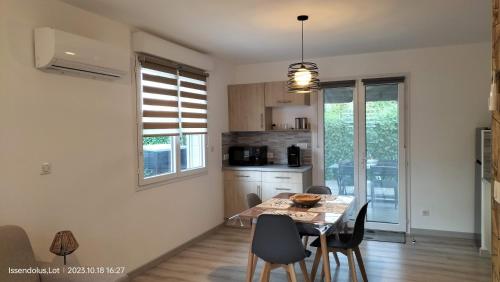 une cuisine et une salle à manger avec une table et des chaises dans l'établissement Studio de jardin Le Cabanon avec SPA, à Issendolus