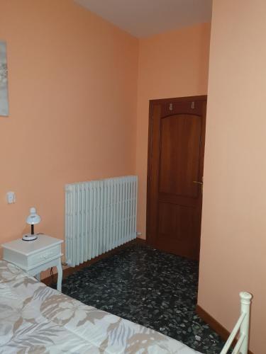 a bedroom with a bed and a wooden door at Andrea affittacamere e B&B in Solignano Nuovo