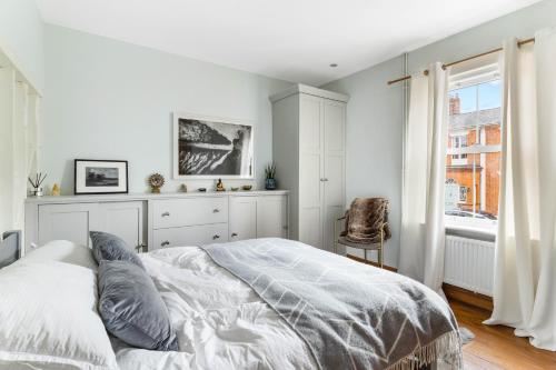 a white bedroom with a bed and a window at Little Braybrooke Cottage in Saffron Walden