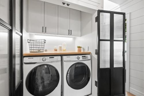 - une buanderie blanche avec lave-linge et sèche-linge dans l'établissement Neptune Hidden Gem, à Encinitas