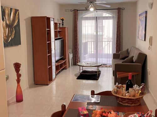 un soggiorno con divano e TV di Regent Court - 3 bedroom apartment within walking distance from Bugibba seafront a San Pawl il-Baħar