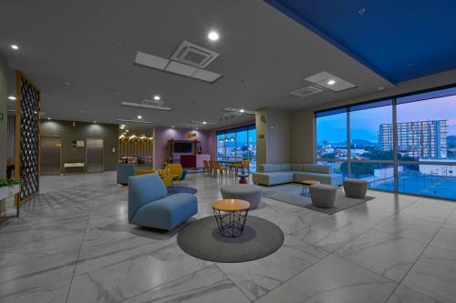 hol budynku z niebieskimi krzesłami i stołami w obiekcie City Express Plus by Marriott Mundo E w mieście Meksyk