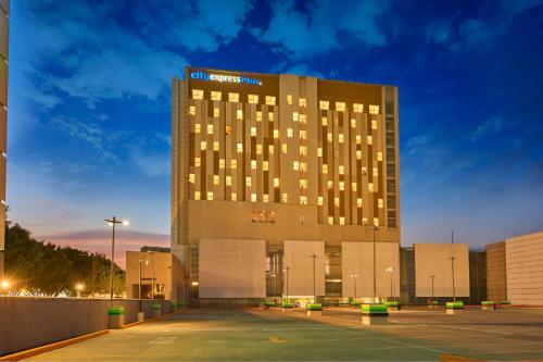 a large building with a parking lot in front of it at City Express Plus by Marriott Ciudad de México Mundo E in Mexico City