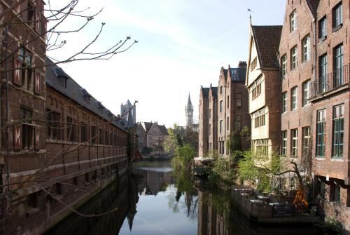 a canal in a city with buildings and a river at Hotel Gravensteen in Ghent