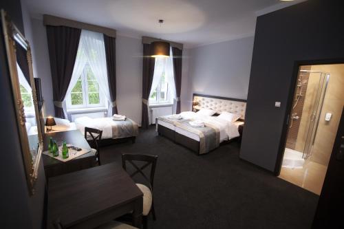 una habitación de hotel con dos camas y una mesa en Villa Elizabeth, en Bolków